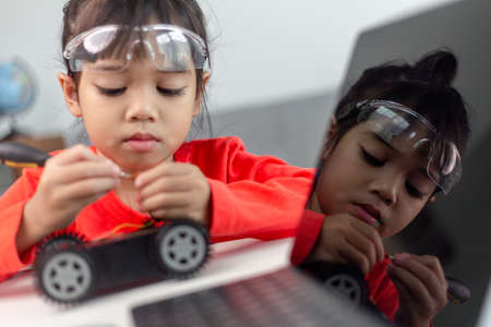 Asia students learn at home in coding robot cars and electronic board cables in STEM, STEAM, mathematics engineering science technology computer code in robotics for kids concept.の写真素材