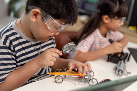 two Asian children having fun learning coding together, learning remotely at home, STEM science, homeschooling education, fun social distancing, isolation, new normal conceptの写真素材