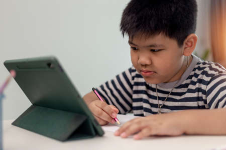 Kid self isolation using tablet for his homework,Child doing using digital tablet searching...