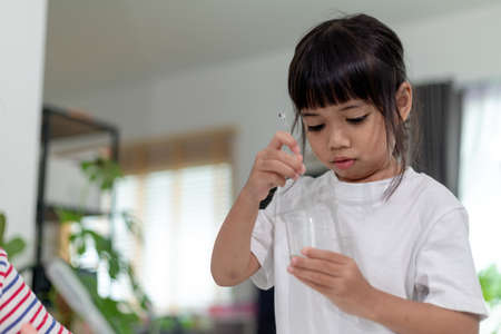 Asian Children enthusiastically watch chemistry experiments.