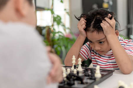Little boy and little girl are playing chess at home.Children playing chessの写真素材