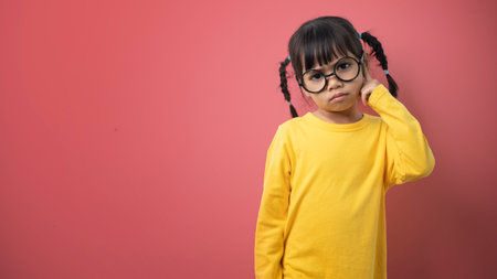 funny child girl wearing glasses on a colored backgroundの写真素材