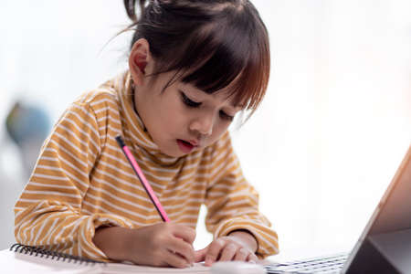 Asian girl students in online learning classes study online with Tablet at home.