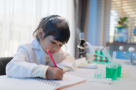 education, science, chemistry, and children concept - kids or students with test tube making experiment at school laboratoryの写真素材