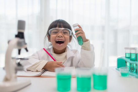 education, science, chemistry, and children concept - kids or students with test tube making experiment at school laboratoryの写真素材