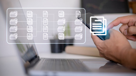Document Management System (DMS) being setup by IT consultant working on laptop computer in office....