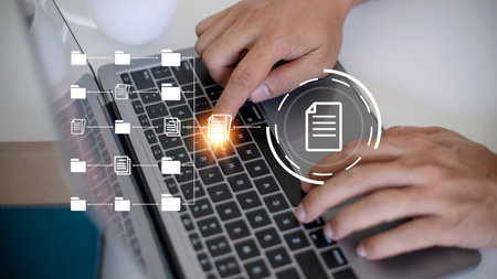 Document Management System (DMS) being setup by IT consultant working on laptop computer in office....