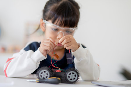 Asia students learn at home in coding robot cars and electronic board cables in STEM, STEAM, mathematics engineering science technology computer code in robotics for kids concept.の写真素材