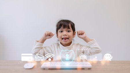 Child safety online. Little girl using laptop at home. icon of internet blocking app on foreground