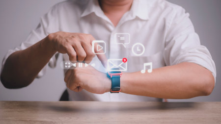 Man working with smart watch in office. New message received notification on screenの写真素材