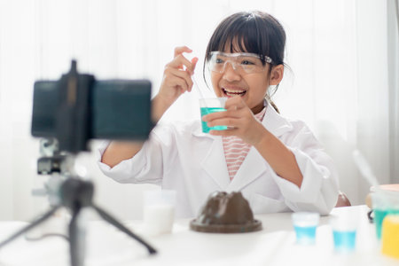 Asian school girl making easy chemistry experiments and recording a video for his followers, Young...