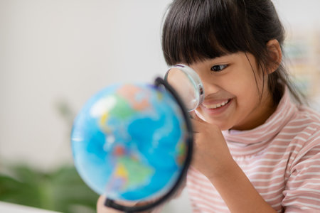 Asian little girl is learning the globe model, concept of save the world and learn through play...