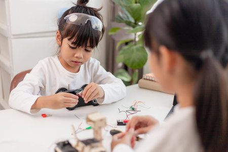 Asia students learn at home in coding robot cars and electronic board cables in STEM, STEAM, mathematics engineering science technology computer code in robotics for kids concept.の写真素材
