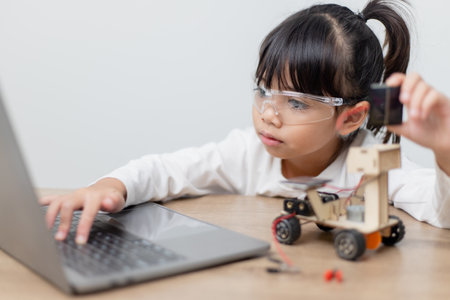 Asia students learn at home in coding robot cars and electronic board cables in STEM, STEAM, mathematics engineering science technology computer code in robotics for kids concept.の写真素材