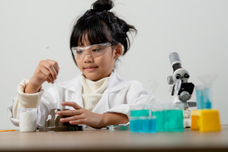 education, science, chemistry and children concept - kids or students with test tube making experiment at school laboratoryの写真素材