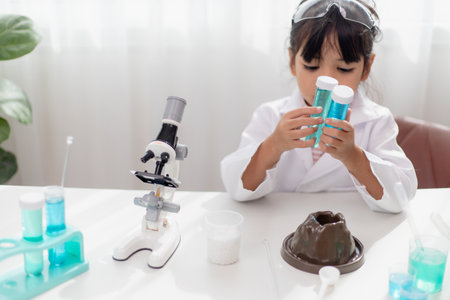 education, science, chemistry and children concept - kids or students with test tube making experiment at school laboratoryの写真素材