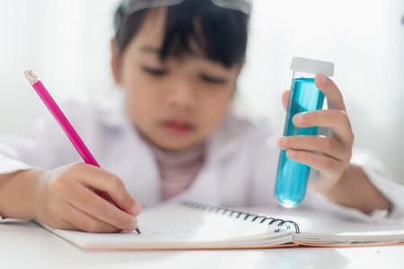 education, science, chemistry and children concept - kids or students with test tube making experiment at school laboratoryの写真素材