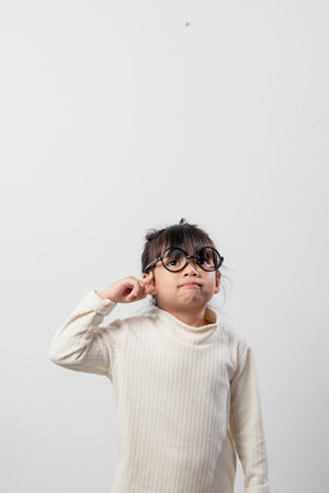 Asian little girl thinking something select focus shallow depth of field with copy spaceの写真素材