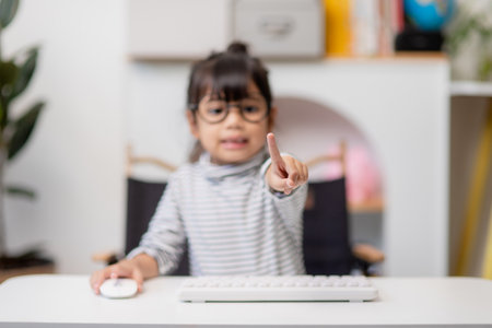education, school, and imaginary screen concept - Asian little girl pointing in the air or imaginary screenの写真素材