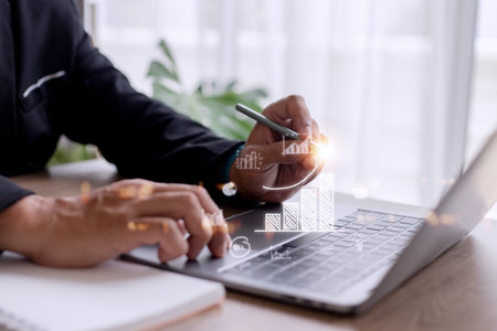Businessman draws an increasing trend arrow and a rising chart from plan to goal. It is a representation of the idea of corporate investment development.の写真素材