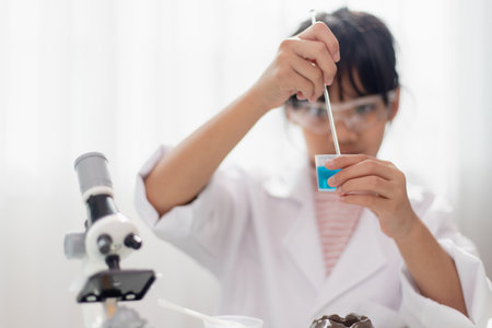 education, science, chemistry and children concept - kids or students with test tube making...