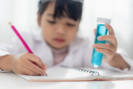 education, science, chemistry and children concept - kids or students with test tube making experiment at school laboratoryの写真素材