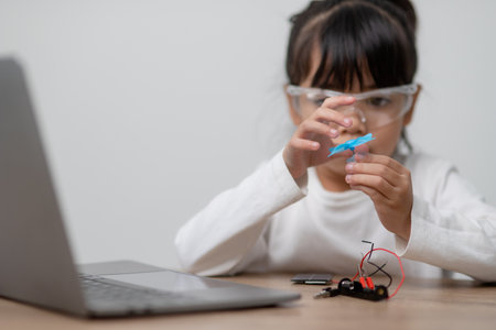 Asia students learn at home in coding robot cars and electronic board cables in STEM, STEAM, mathematics engineering science technology computer code in robotics for kids concept.の写真素材