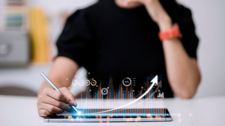 people using tablets And using his finger to touch the screen With a business graph showing up in a...