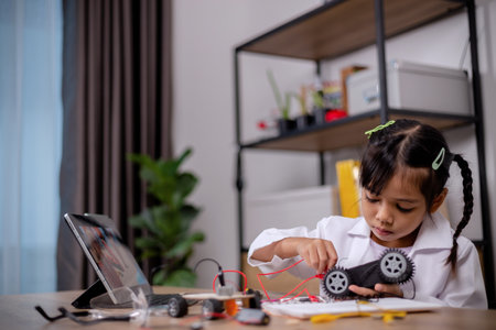Asian students learn at home by coding robot cars and electronic board cables in STEM, STEAM,...
