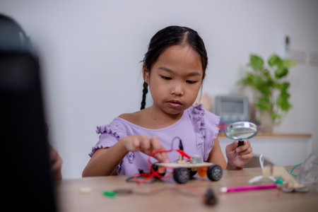 Asian students learn at home by coding robot cars and electronic board cables in STEM, STEAM, mathematics engineering science technology computer code in robotics for kids' concepts.の写真素材