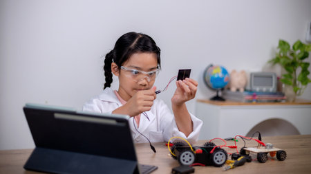 Asian students learn at home by coding robot cars and electronic board cables in STEM, STEAM,...