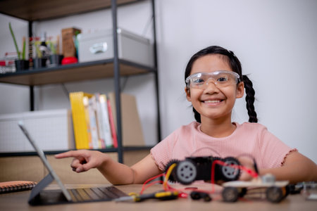 Asian students learn at home by coding robot cars and electronic board cables in STEM, STEAM, mathematics engineering science technology computer code in robotics for kids' concepts.の写真素材