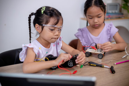 Asian students learn at home by coding robot cars and electronic board cables in STEM, STEAM, mathematics engineering science technology computer code in robotics for kids' concepts.の写真素材