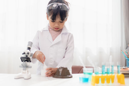 education, science, chemistry and children concept - kids or students with test tube making experiment at school laboratoryの写真素材