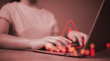 developer using computer laptop with triangle caution warning sign for notification error and maintenance concept.の写真素材