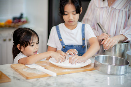 Two little cute Asian girls, learning how to make bread and bakery with a curious and happy smile...