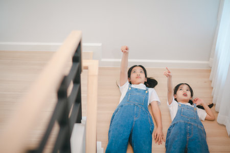 Sibling Asian girls having fun on the stairs.の写真素材