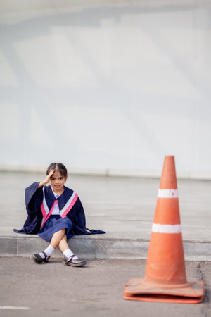 Happy Asian girls in graduation gowns on their graduation day at school.Graduation concept with copy space.の写真素材
