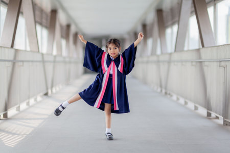 Happy Asian girls in graduation gowns on their graduation day at school.Graduation concept with copy space.の写真素材