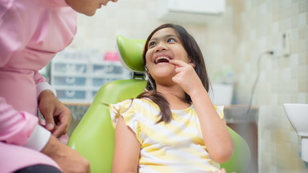 Friendly young dentist examining happy child teeth in dental clinic. Dentistry concept.の写真素材