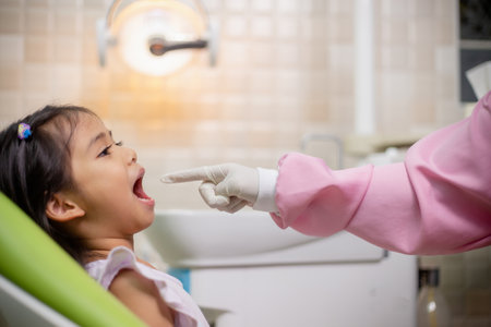 Friendly young dentist examining happy child teeth in dental clinic. Dentistry concept.の写真素材
