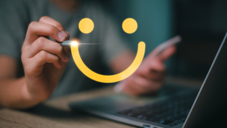 Women hand drawing a smiling happy face on a futuristic virtual interface screen. Client satisfaction, service, or product evaluation concept.の写真素材