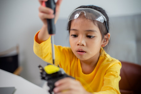 STEM education concept. Asian students learn at home by coding robot arms in STEM, mathematics engineering science technology computer code in robotics for kids' concepts.の写真素材