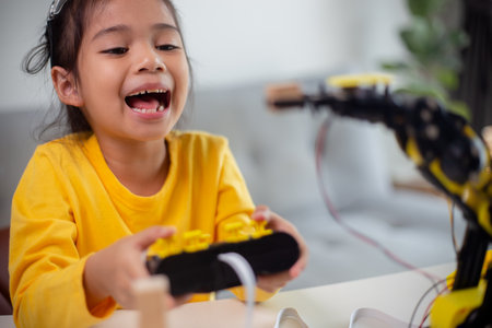 STEM education concept. Asian students learn at home by coding robot arms in STEM, mathematics engineering science technology computer code in robotics for kids' concepts.の写真素材