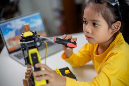 STEM education concept. Asian students learn at home by coding robot arms in STEM, mathematics engineering science technology computer code in robotics for kids' concepts.の写真素材