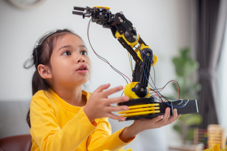 STEM education concept. Asian students learn at home by coding robot arms in STEM, mathematics engineering science technology computer code in robotics for kids' concepts.の写真素材