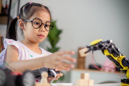 STEM education concept. Asian students learn at home by coding robot arms in STEM, mathematics engineering science technology computer code in robotics for kids' conceptsの写真素材