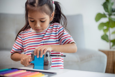 Student child girl using Pencil sharpener while doing homework. education concept.