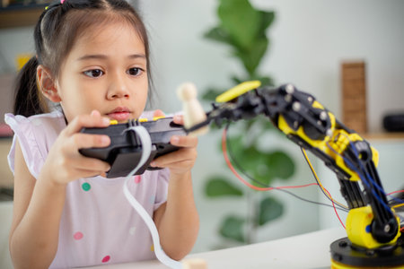 STEM education concept. Asian students learn at home by coding robot arms in STEM, mathematics engineering science technology computer code in robotics for kids' conceptsの写真素材