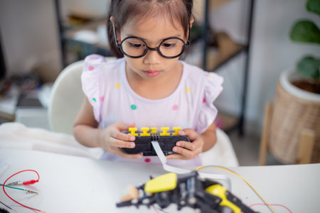 STEM education concept. Asian students learn at home by coding robot arms in STEM, mathematics engineering science technology computer code in robotics for kids' conceptsの写真素材